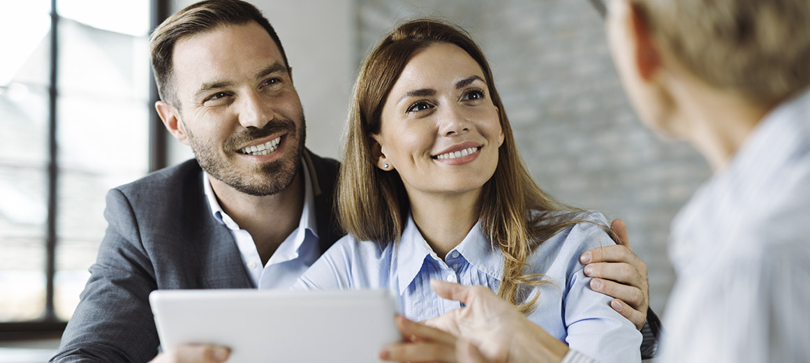 young couple smiling while holding a meeting