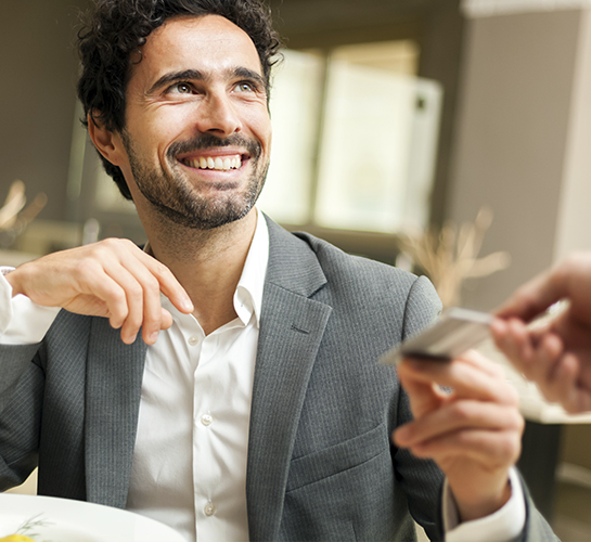 guy smiling handing card to a server