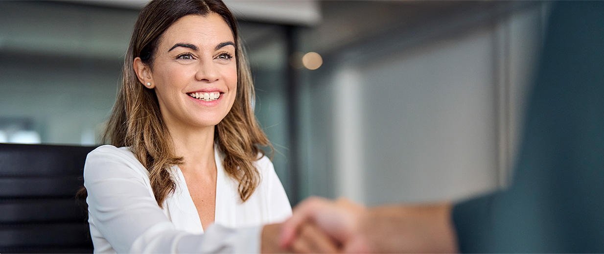 woman smiling shaking hands with someone