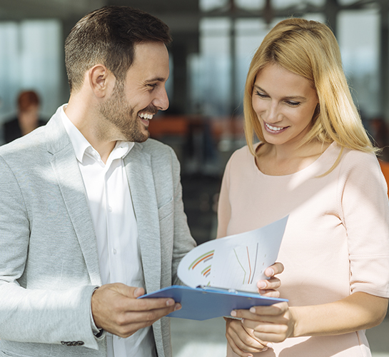 a man and a woman smiling looking at a clipboard