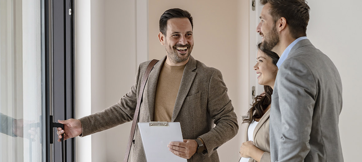business man holding door open for a young couple