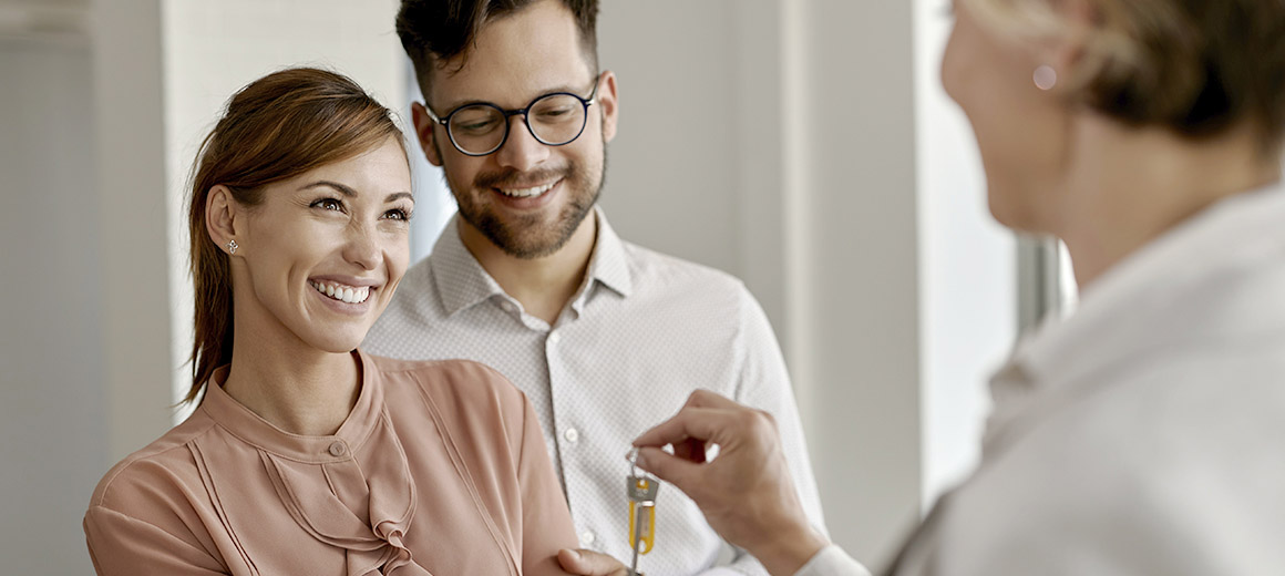women handing keys to a young couple