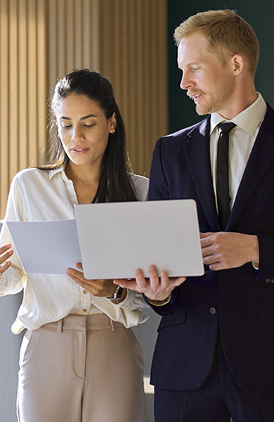2 people at office looking at same laptop