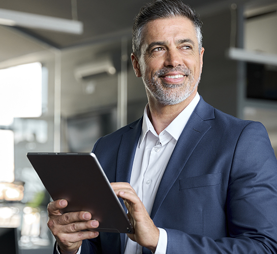 businessman smiling and holding a tablet